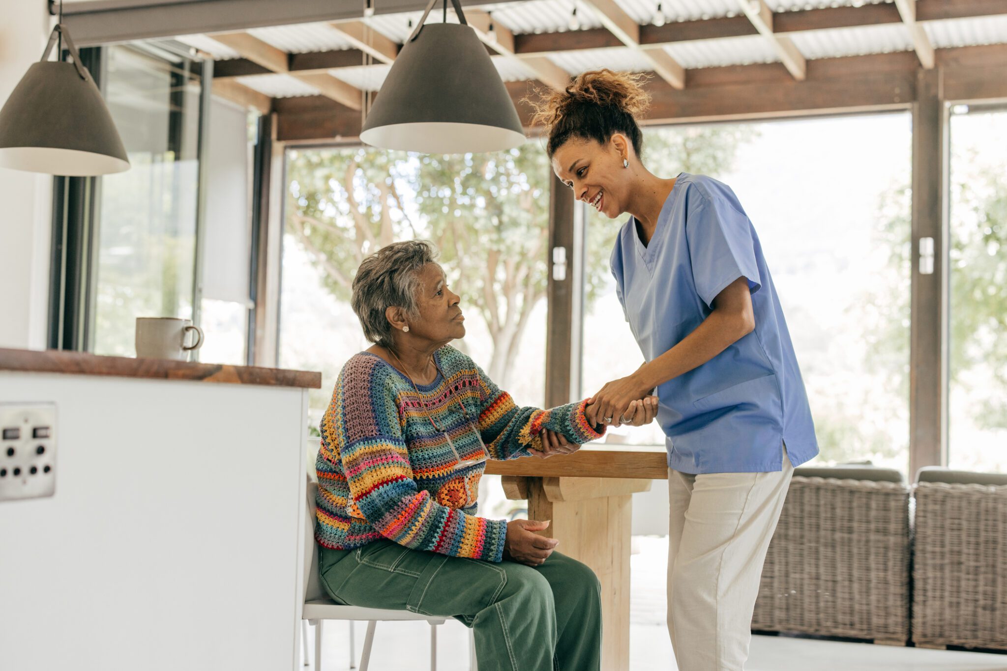 Caregiver assisting elderly woman at home.
