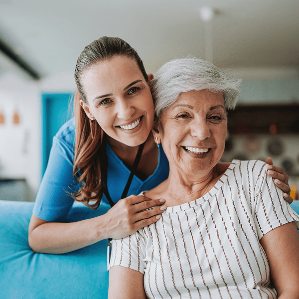 Smiling caregiver with happy elderly woman.