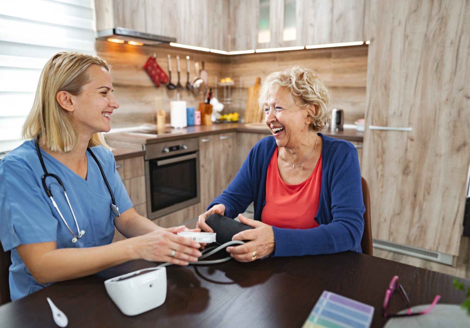 Nurse assisting elderly woman with blood pressure.